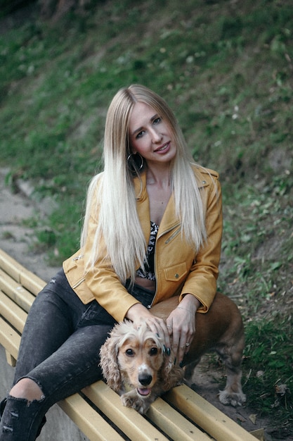 La ragazza con il cane cammina nel parco