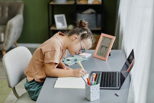 Photo young girl with down syndrome studying at home