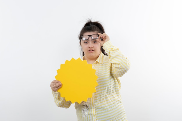 Young girl with down syndrome with yellow speech bubble posing.