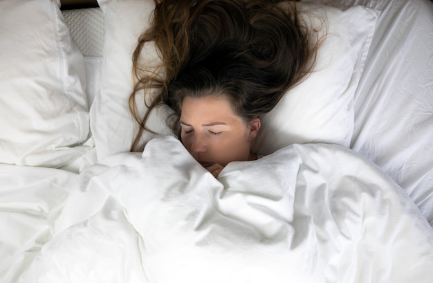 young girl with freckles sleeping with white sheets top view portrait of the beautiful young woman