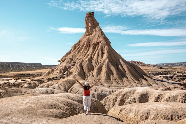 사진 bardenas reales navarra에서 여행하는 모자 갈색 셔츠와 흰색 바지를 입은 어린 소녀