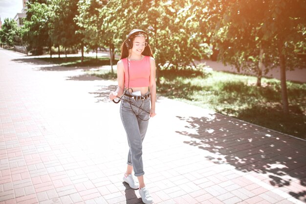 Young girl with headphones walking on the street