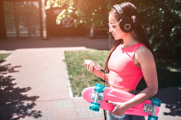 Young girl with headphones walking on the street