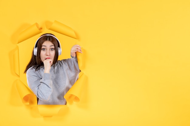 young girl with headphones on a yellow paper background ultrasound music audio sound