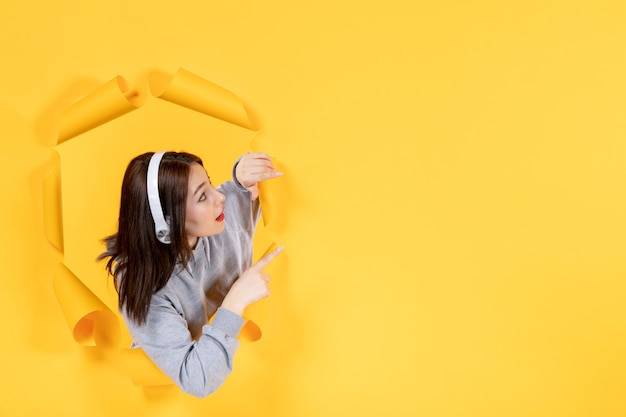 young girl with headphones on yellow paper background ultrasound sounds music audio