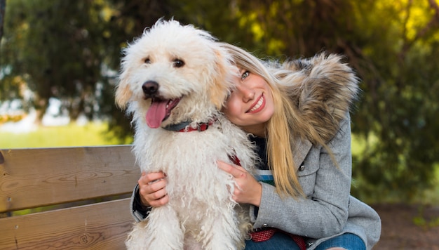 公園で彼女の犬を持つ若い女の子