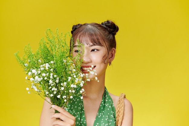 Young girl with large bouquet of small pink wildflowers laughs