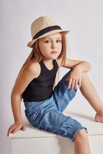 Young girl with long hair posing on a white wall. Beautiful face and smile. 