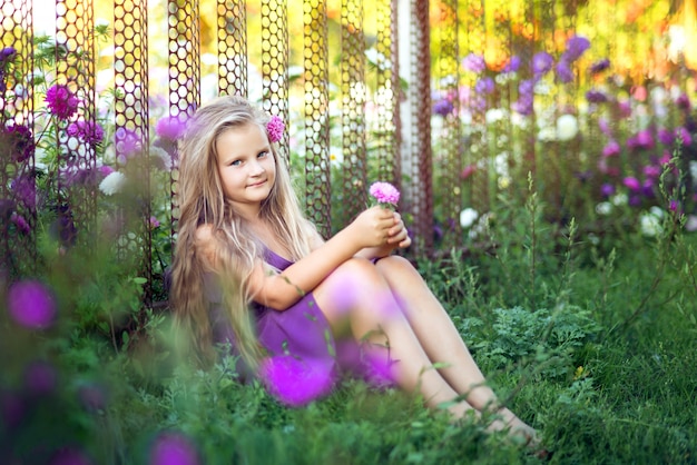 Молодая девушка с длинными волосами, сидя на траве