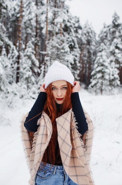 冬の風景に長い赤い髪の少女。