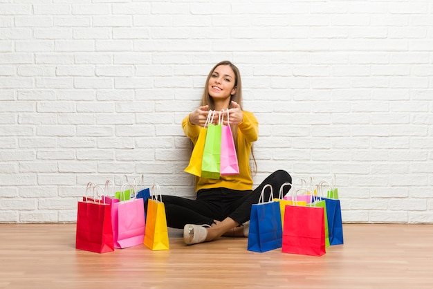 Young girl with lot of shopping bags holding a lot of shopping bags