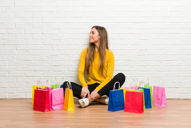 Young girl with lot of shopping bags in lateral position