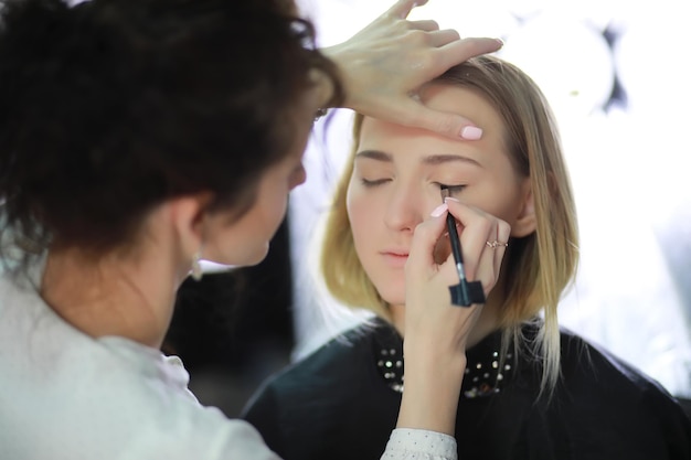 Young girl with a makeup artist