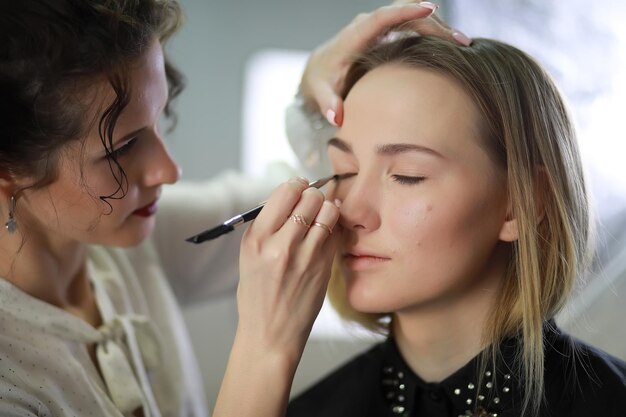 Young girl with a makeup artist