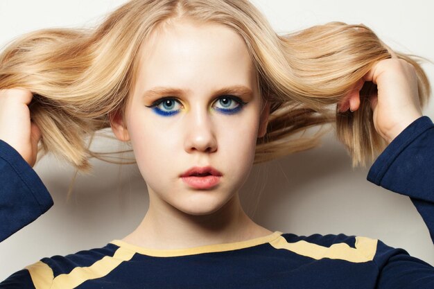 Photo young girl with makeup and blonde hair on white background