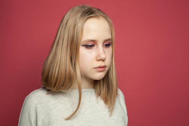 Young girl with makeup on bright pink background