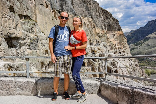 Young girl with a man with a view of the cave city of Vardzia Vardziacave monastery in South Georgia April 30 2019 Georgia