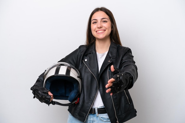 Young girl with a motorcycle helmet isolated on white background shaking hands for closing a good deal