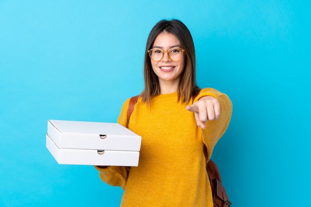 Young girl with pizzas over blue wall