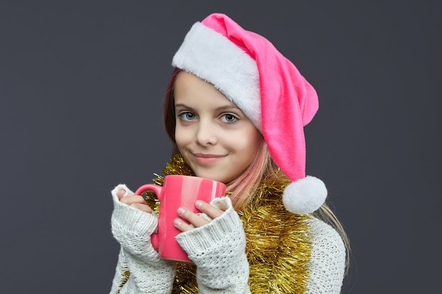 Young girl with a Santa hat and mug