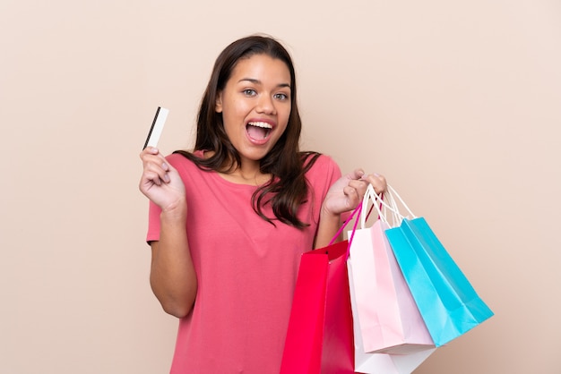 Young girl with shopping bag over isolated wall