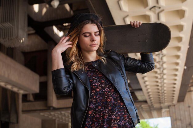 Young girl with the skateboard looking down