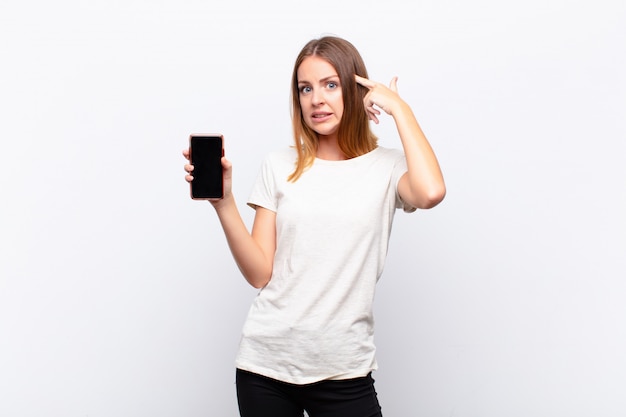 young girl with smartphone pointing to her head