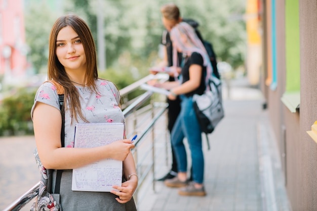 Young girl with studies on university porch