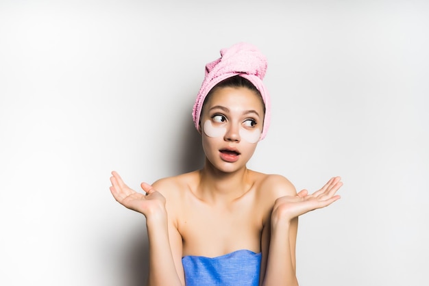 A young girl with an unfinished mask on her face makes a surprised gesture