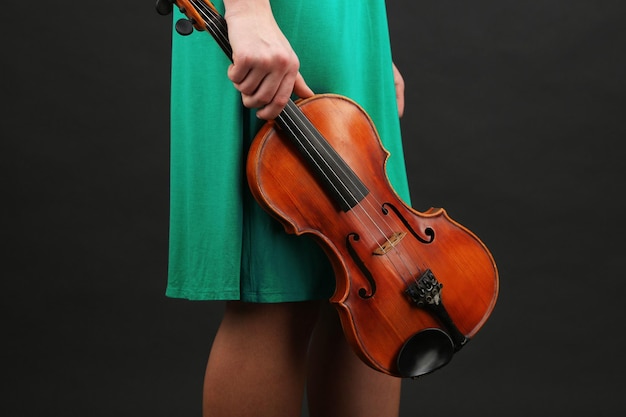 Young girl with violin on grey background