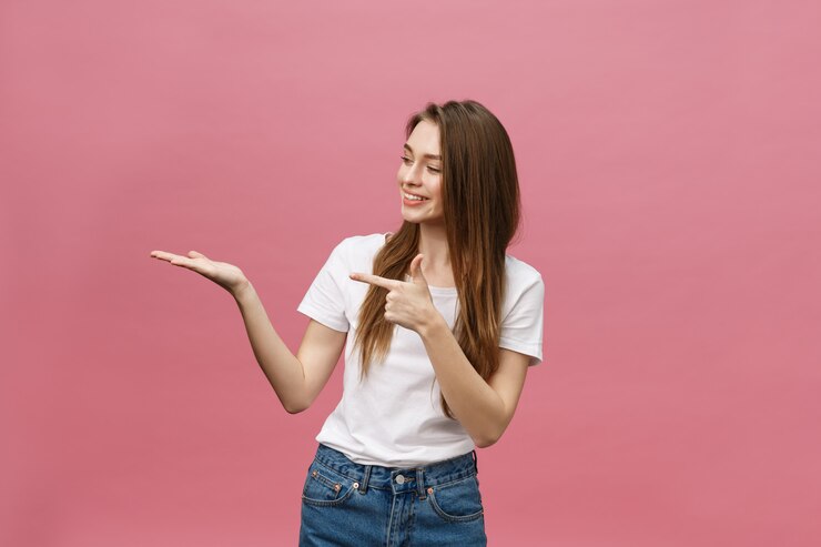 Photo young girl with white shirt pointing hand on side to present a product
