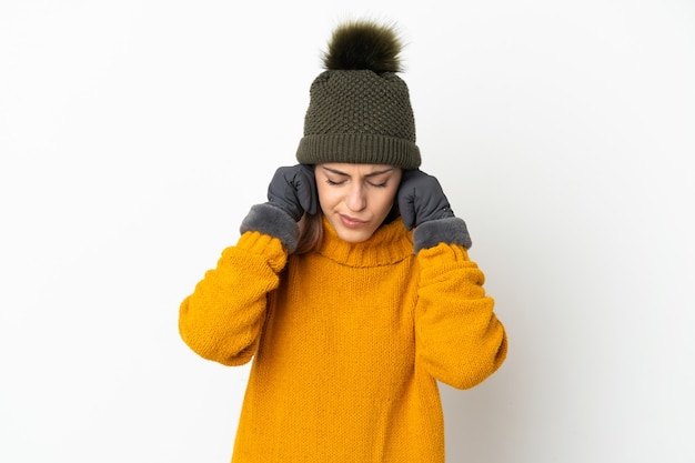 Young girl with winter hat isolated frustrated and covering ears