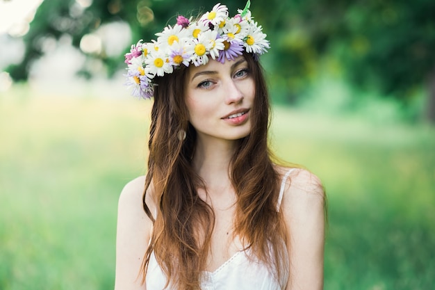 夏の公園で彼女の頭に花輪を捧げる少女