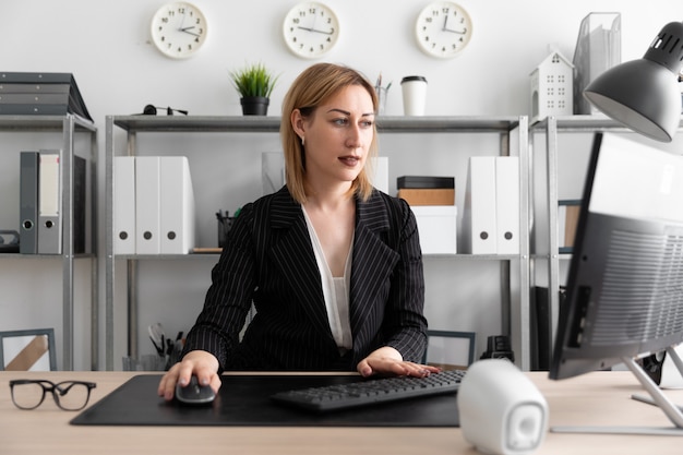 A young girl working at a computer in the office.