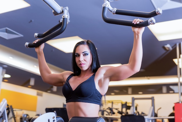 A young girl working out at a weight lifting machine in the Gym	