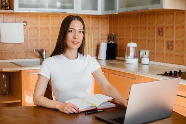 A young girl works at home on a remote site. Distance learning. Stay at home.