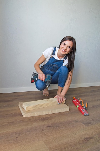 A young girl works with a drill. cordless cordless drill -\
screwdriver with drill.construction tool