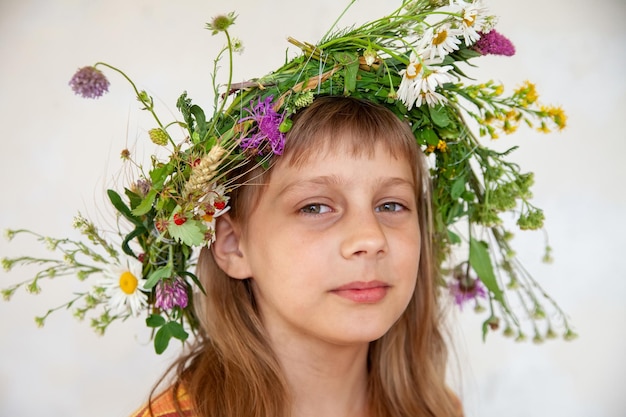 Young girl in wreath of wild flowers