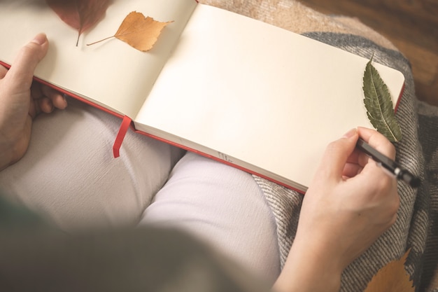 Photo young girl writing diary and resting at home on moody autumn days