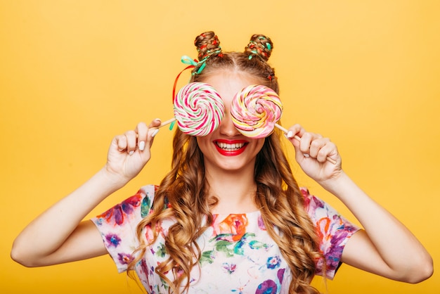 Young girl on the yellow holding sweets