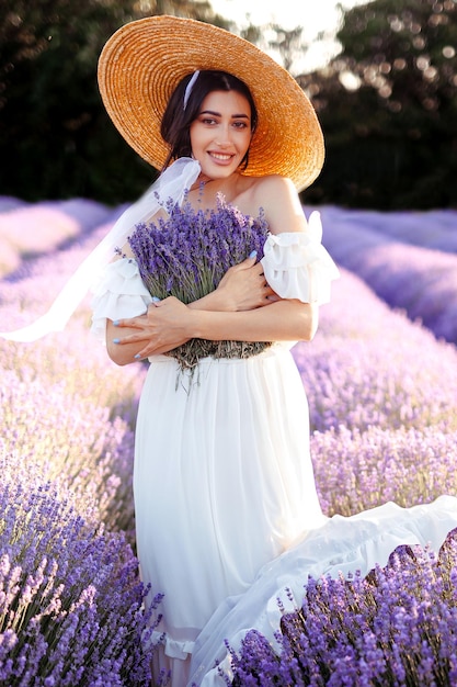 Un ritratto di una giovane donna bellissima in un campo di lavanda