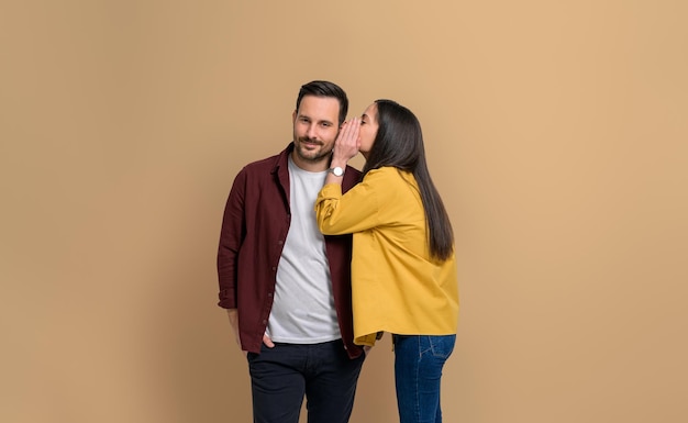 Young girlfriend whispering her desires into handsome boyfriends ear