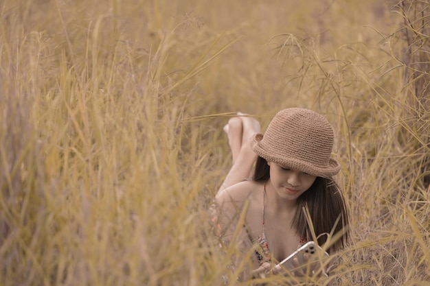 Young girll wearing a hat lying on the grass