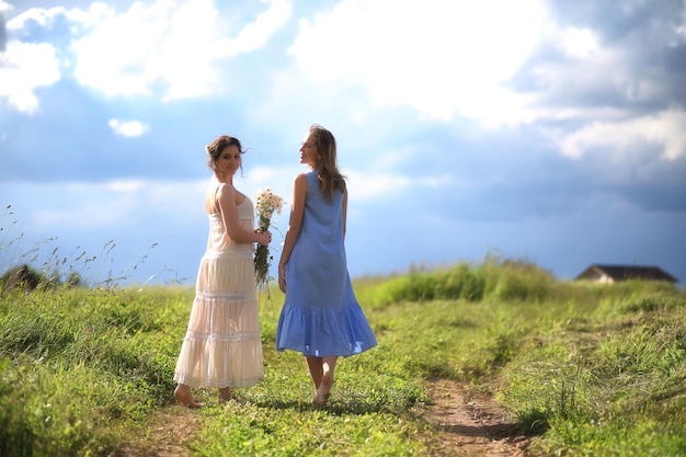 Young girls are walking in the field