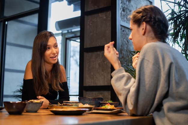 アジアンスタイルのカフェでチャットの若い女の子