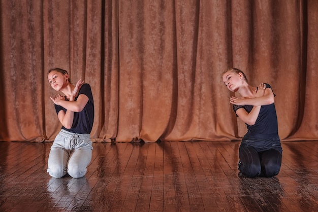 Young girls dancers work out dance moves on stage.