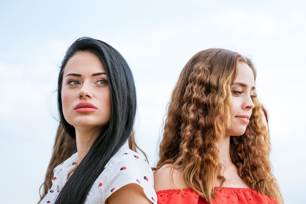 Young girls girlfriend outdoors on a background of blue sky relationship concept