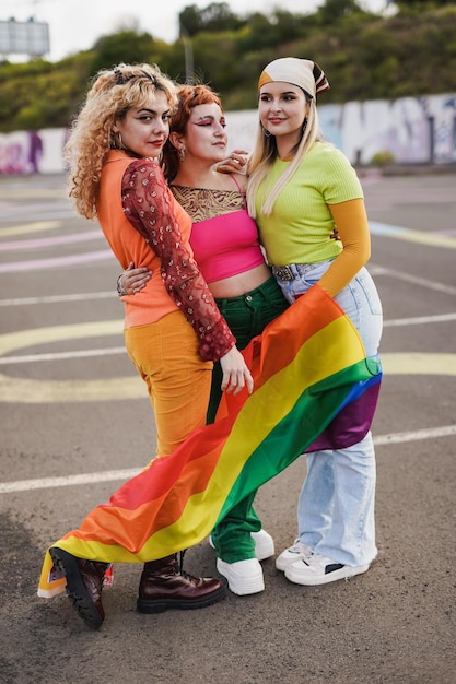 Young girls holding LGBT rainbow flag outdoor at gay pride parade