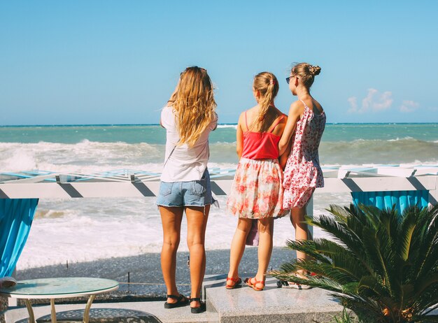 Photo young girls look at stormy black sea