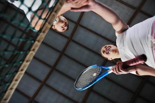 Photo young girls playing tennis game indoor